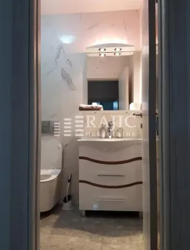 View of a modernly equipped bathroom with a vanity and toilet. - image 9