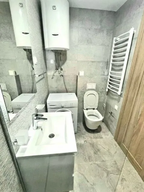 Savremeno opremljeno kupatilo sa tuš kabinom, umivaonikom i wc šoljom.