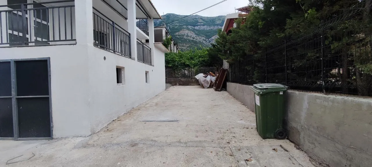 View of the exterior part of the property with a yard and fence.