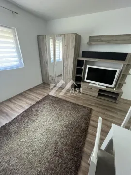 Dnevna soba sa televizorom, ormarom i tepihom na podu. - image 6