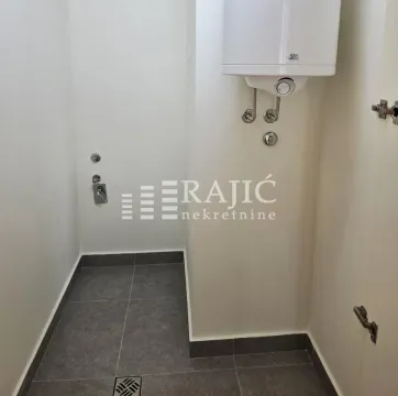 Smaller bathroom with tiling and a water heater. - image 6