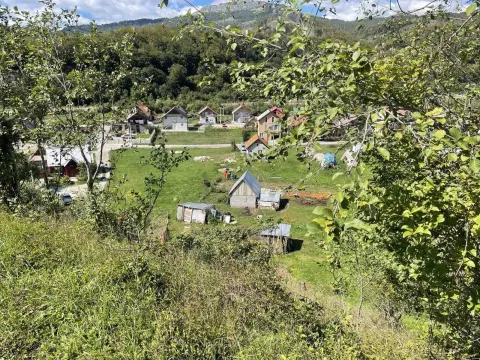Pogled na zeleni plac sa kućama u planinskom okruženju. - image 6