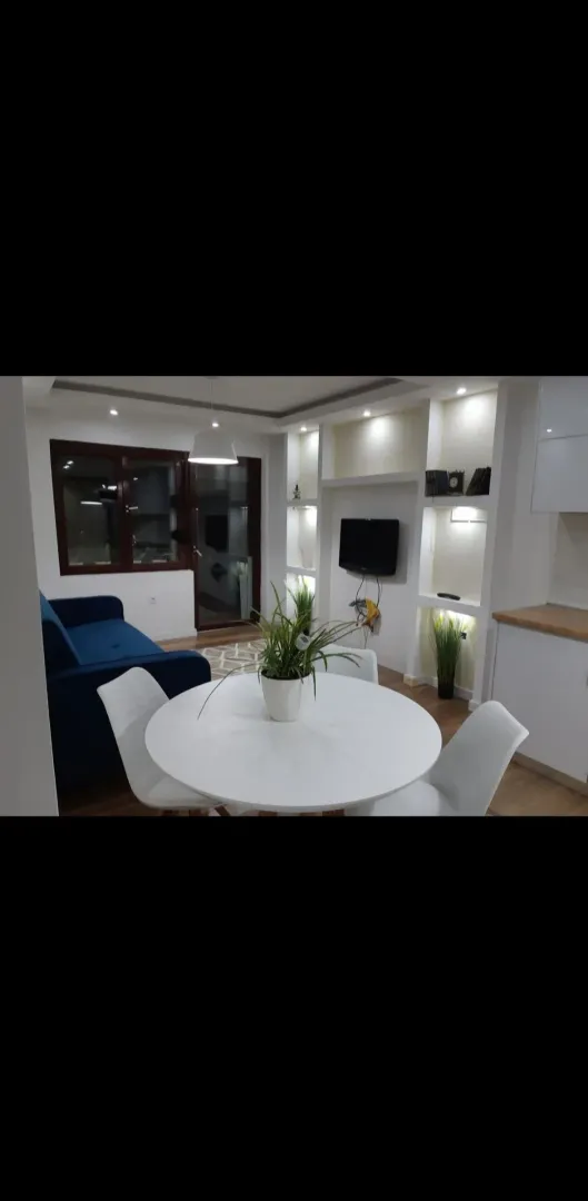 Dnevni boravak sa trpezarijom i modernim nameštajem.