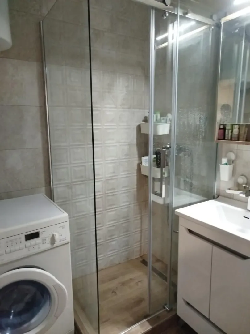 Kupatilo sa tuš kabinom, umivaonikom i veš mašinom.