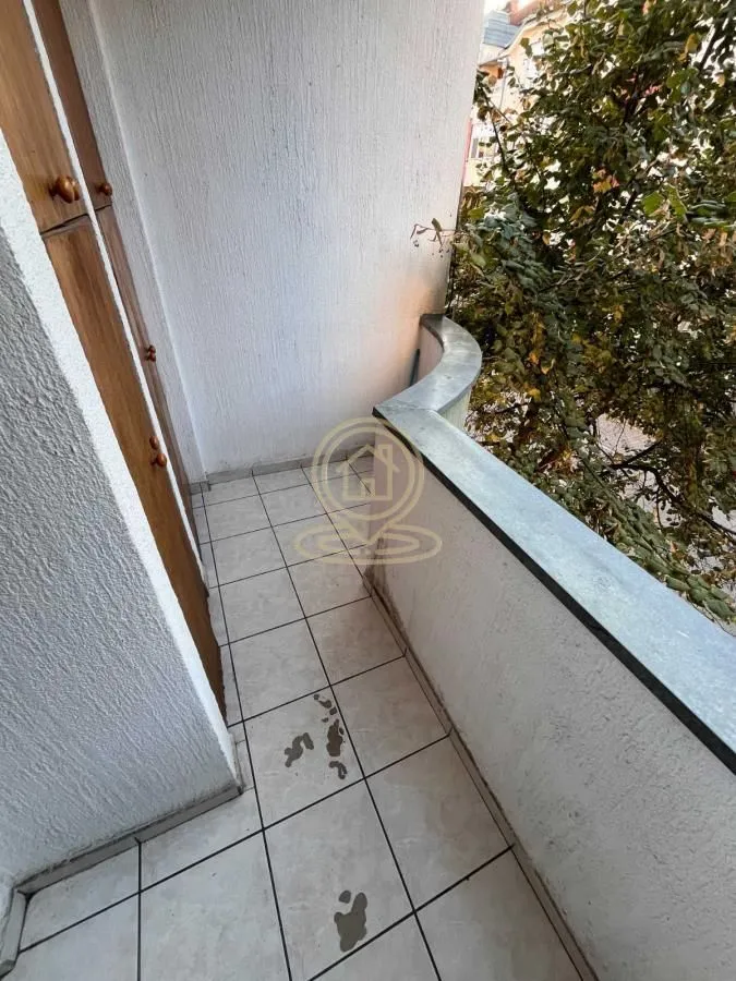 Uska terasa sa popločanim podom i ugrađenim ormarom uz zid.