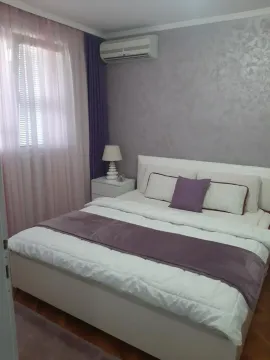 Furnished bedroom with a double bed, bedside table, and air conditioning. - image 21