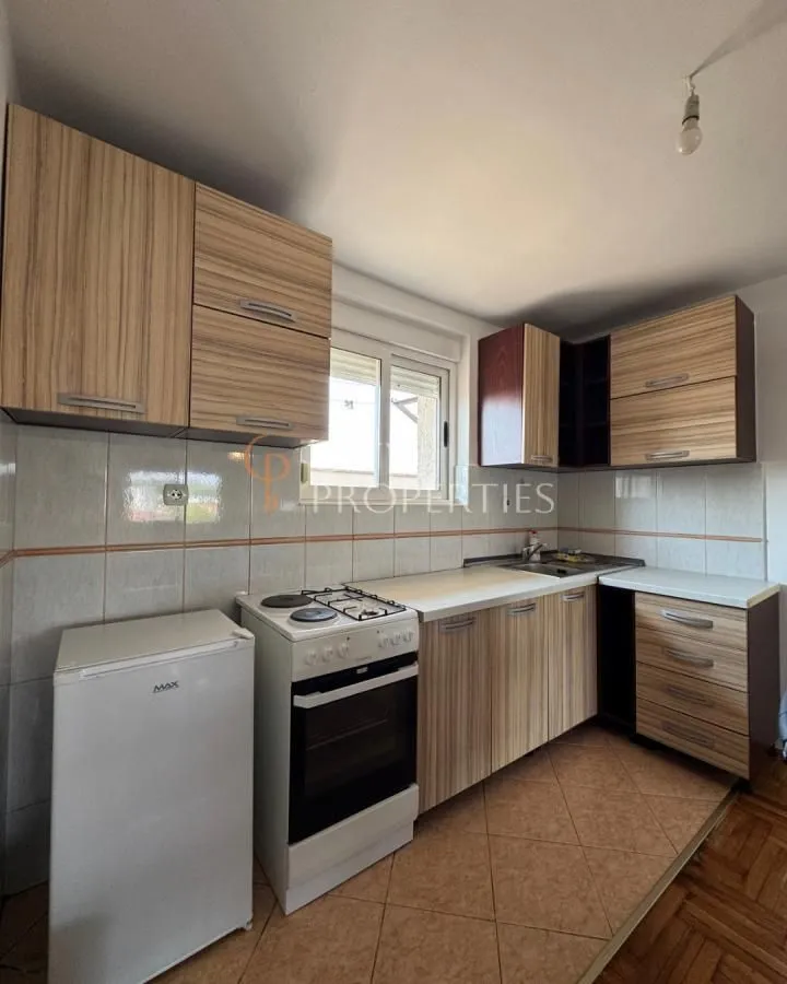 Smaller kitchen with wooden cabinets, a stove, and a refrigerator.
