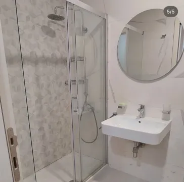 Modernly equipped bathroom with a shower cabin and sink. - image 5