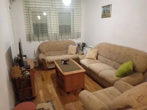 Dnevna soba sa garniturom za sjedenje, drvenim klub stolom i televizorom. - image 11