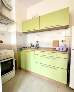 Manja kuhinja sa svijetlim zelenim elementima i bijelim šporetom. - image 6