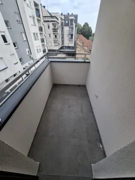 Prazan balkon sa podnim pločicama i pogledom na okolne zgrade. - image 7
