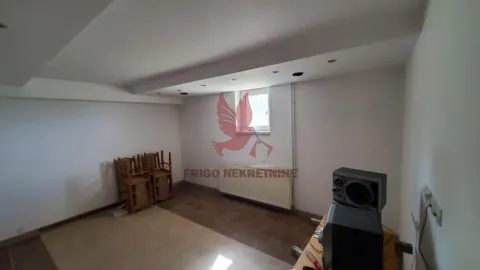 Prazna prostorija sa spuštenim plafonom, radijatorom i složenim stolicama u uglu. - image 19