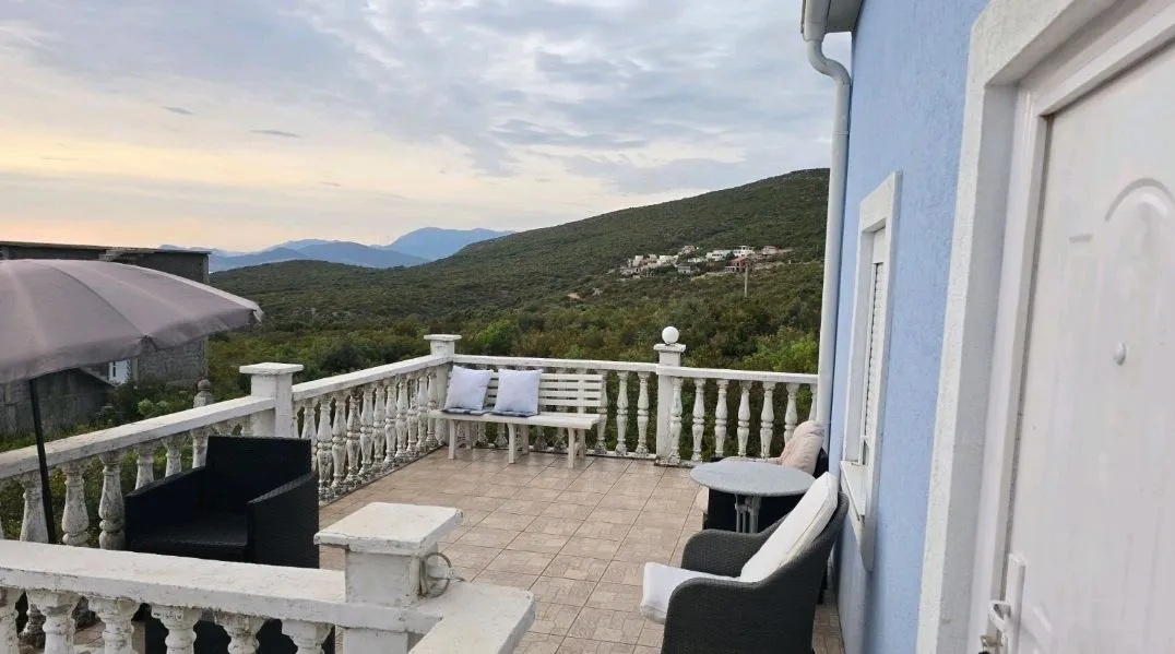 Spacious terrace with seating furniture and a view of nature.