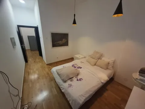 Nameštena spavaća soba sa bračnim krevetom, drvenim podom i slikom na zidu. - image 12