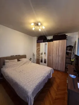 Nameštena spavaća soba sa bračnim krevetom, velikim garderoberom i drvenim podom. - image 5