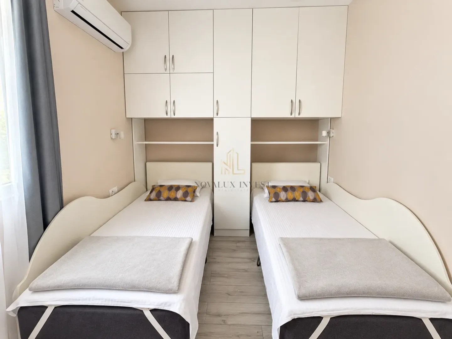Bedroom with two single beds and fitted wardrobes.