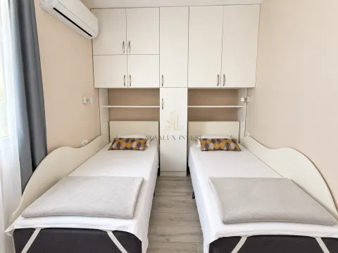 Bedroom with two single beds and fitted wardrobes. - image 9