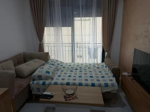 Bedroom with a bed, sofa, TV, and balcony access. - image 7