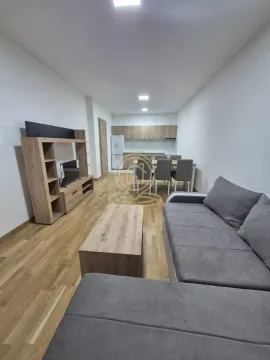 Dnevna soba sa garniturom, TV komodom i trpezarijom u pozadini. - image 4