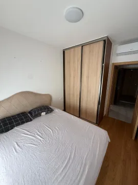 A bedroom with a double bed, a large wardrobe, and laminate flooring. - image 4