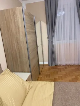 Namještena spavaća soba sa krevetom, garderoberom i prozorom sa zavjesama. - image 19