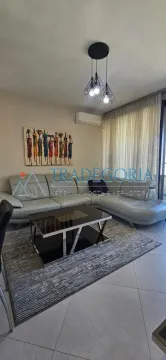 Dnevna soba sa ugaonom garniturom, klub stolićem i slikom na zidu. - image 6