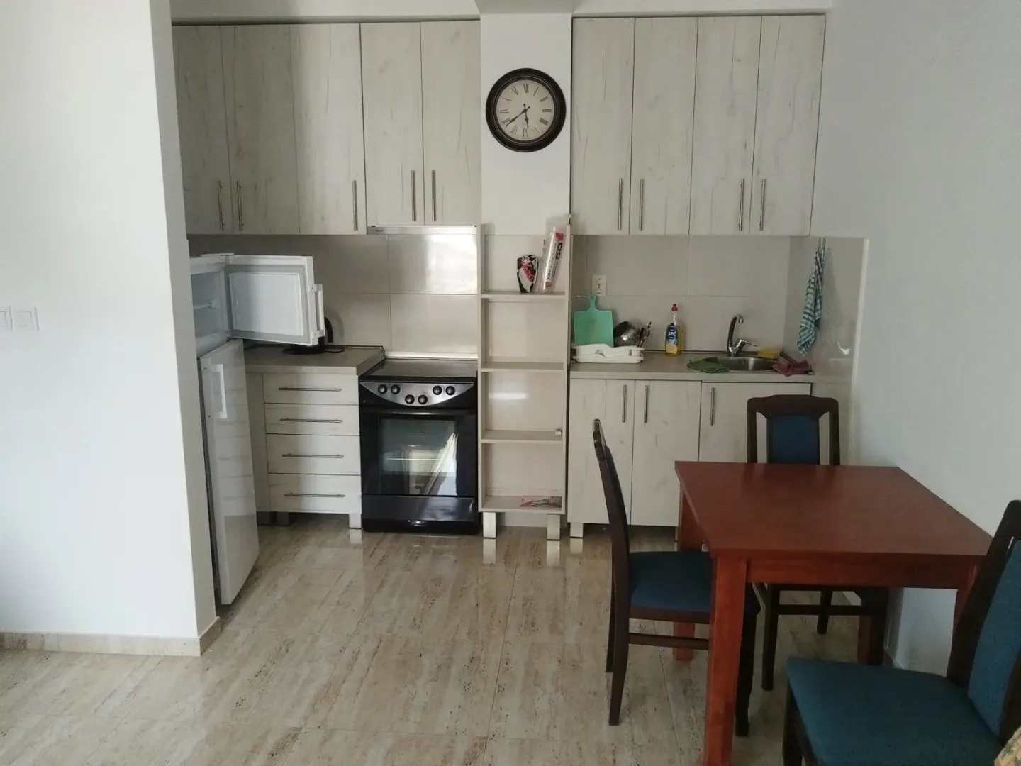 Small kitchen with light cabinets and a dining table.