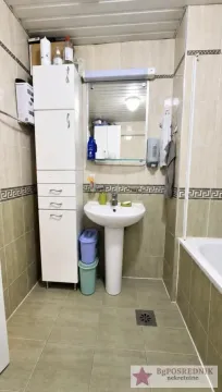 Bathroom with a washbasin, mirror, and tall storage cabinet. - image 12