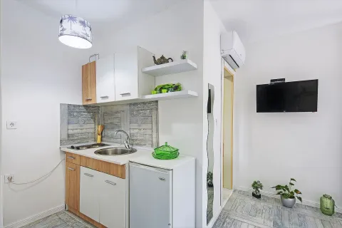 Small kitchen with a sink, cabinets, and a refrigerator within the room. - image 3