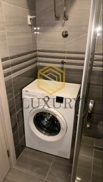 Bathroom with ceramic tiles and a washing machine. - image 3