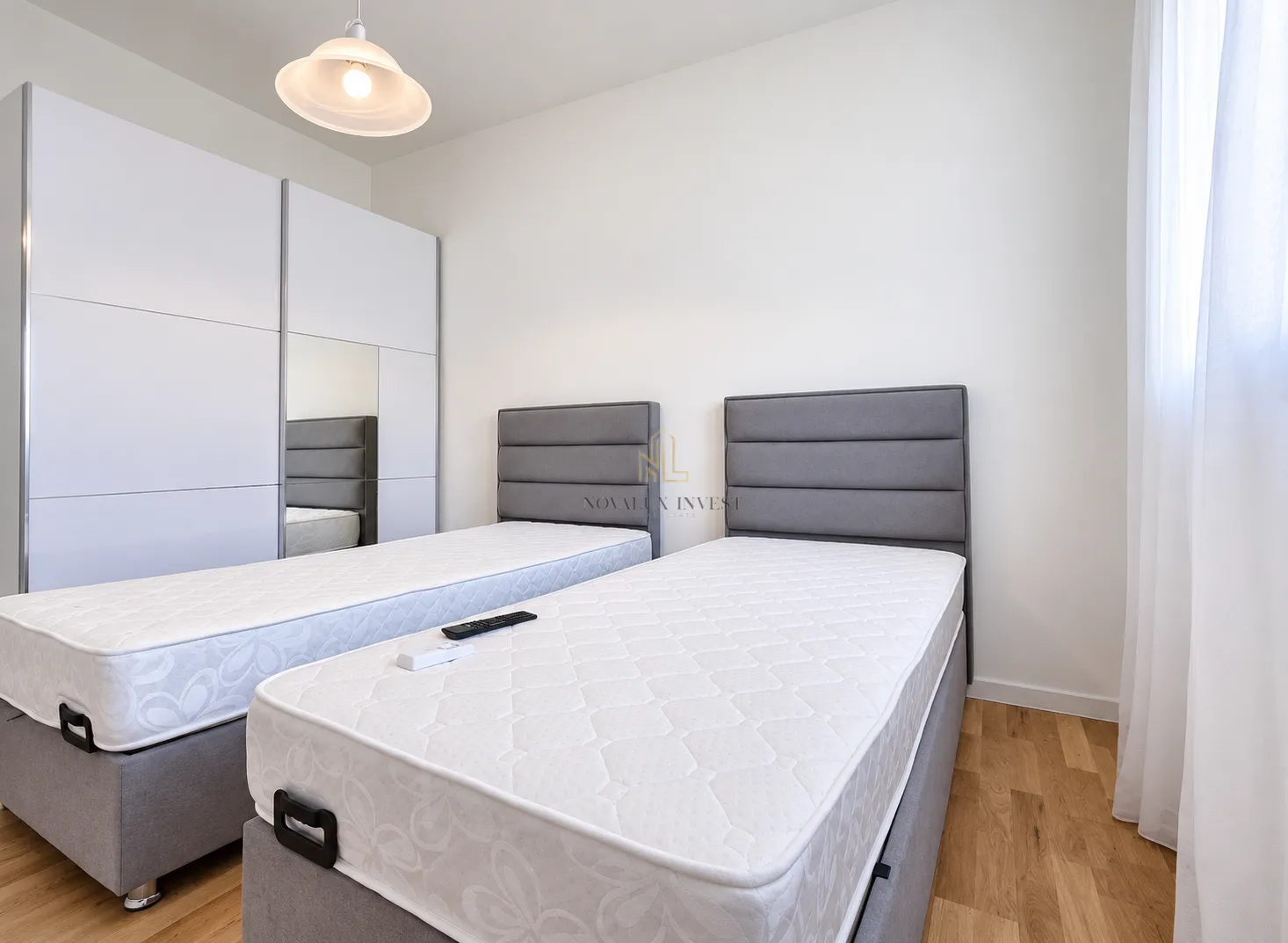 Bedroom with two beds and a white wardrobe.