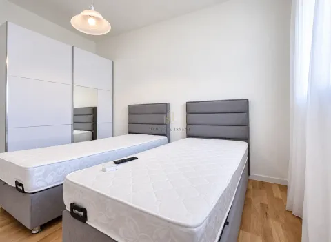 Bedroom with two beds and a white wardrobe. - image 8