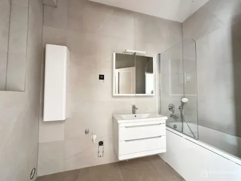 Moderne kupatilo sa kadom, staklenim paravanom i bijelim umivaonikom sa ormarićem. - image 9