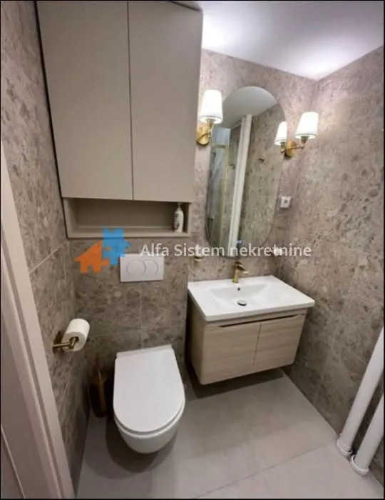 Modern bathroom equipped with a washbasin, toilet, and wall cabinet.