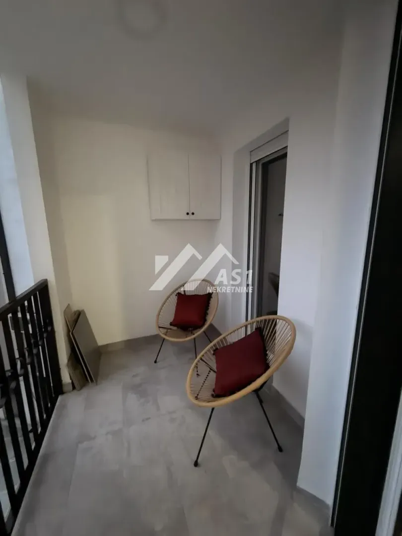 Manji natkriveni balkon sa dve fotelje i jastucima.
