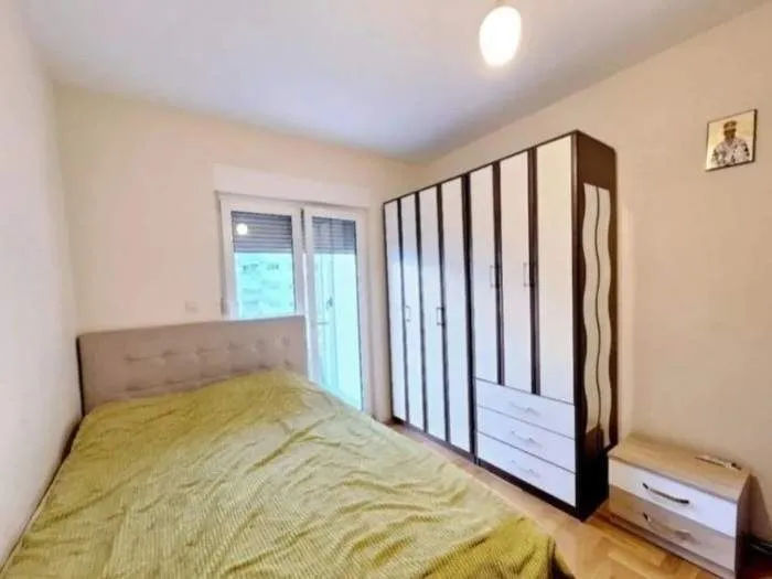 Svijetla spavaća soba sa velikim ormarom i bračnim krevetom.