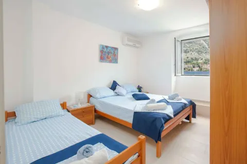 Bedroom with two beds and a sea view through the window. - image 11