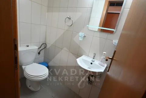 Small bathroom with white tiles, toilet, washbasin, and mirror. - image 13