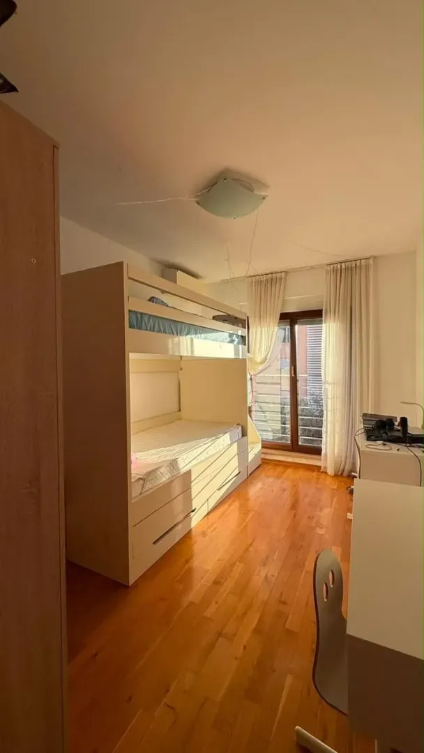 Dječija soba sa krevetom na sprat, radnim stolom i drvenim podom.