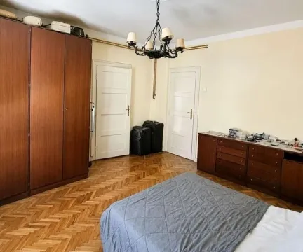 Spavaća soba sa bračnim krevetom, drvenim ormarom, komodom i parketom. - image 19