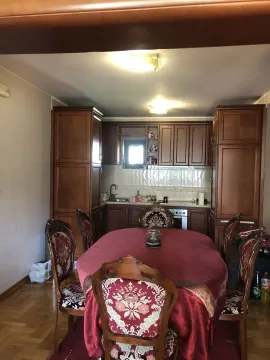 Dining area with a large table and a classic wooden kitchen in the background. - image 12