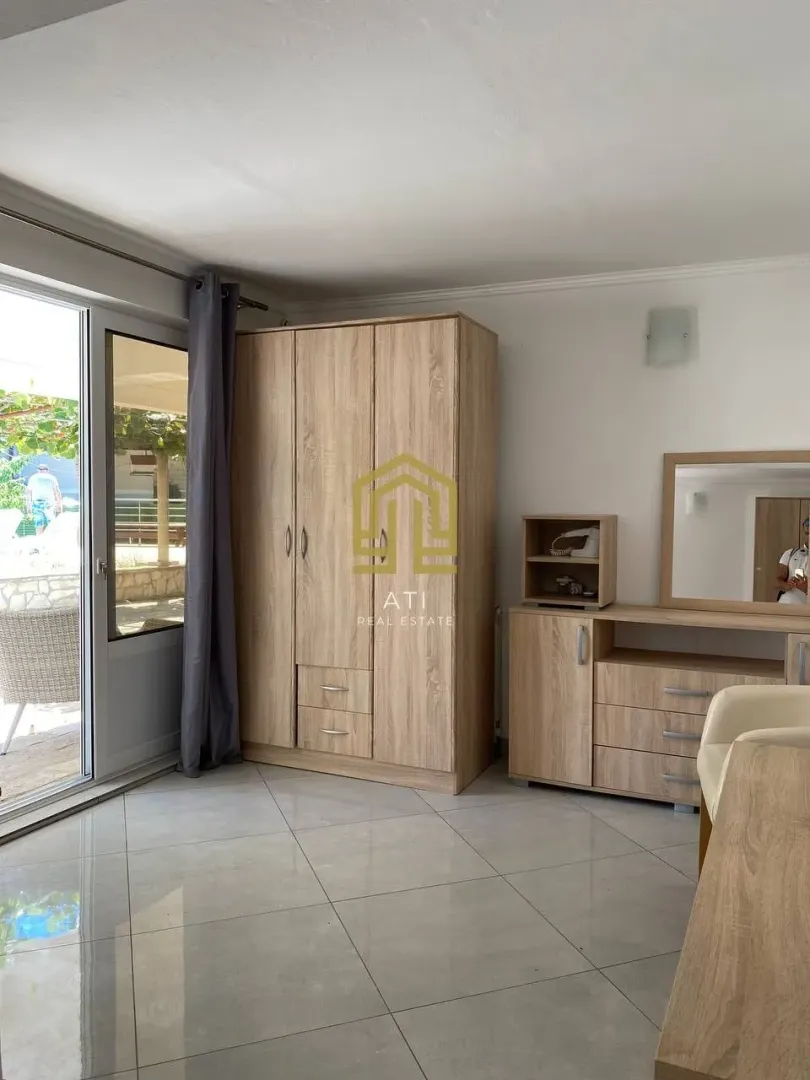 Furnished bedroom with a wooden wardrobe and chest of drawers.