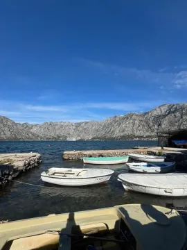 Pogled na more i planine sa privezanim čamcima u obali. - image 9