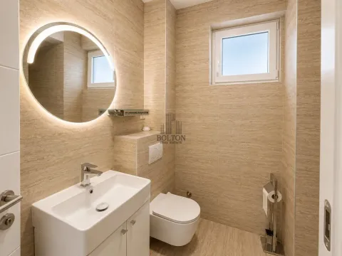 Moderno opremljeno kupatilo sa umivaonikom, WC šoljom i okruglim ogledalom sa pozadinskim osvetljenjem. - image 5