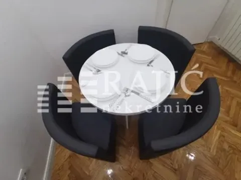 Small dining table with four armchairs set for lunch. - image 3