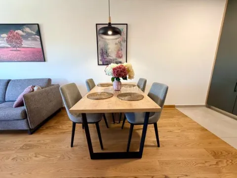 Modern dining area with a wooden table and grey chairs as part of the living room. - image 5