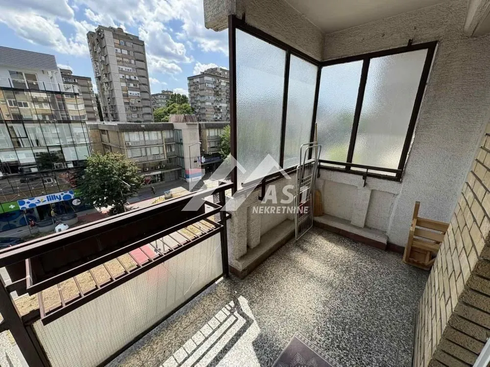 Furnished balcony overlooking the city street and surrounding buildings.