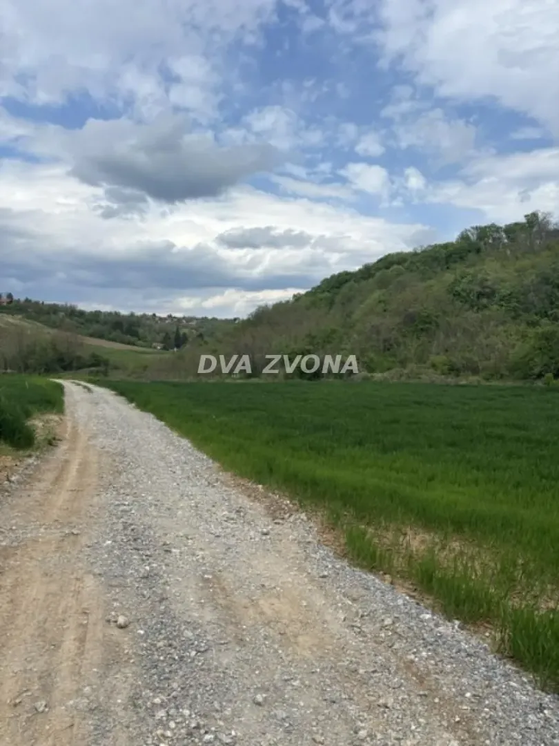 Makadamski put pored zelenih površina sa pogledom na okolnu prirodu.