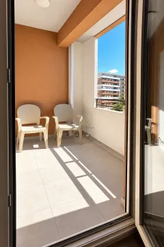 Furnished balcony with two chairs and a city view. - image 4