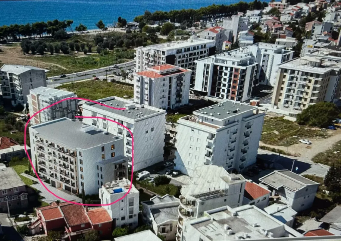Pogled iz vazduha na stambenu zgradu u naselju blizu mora.